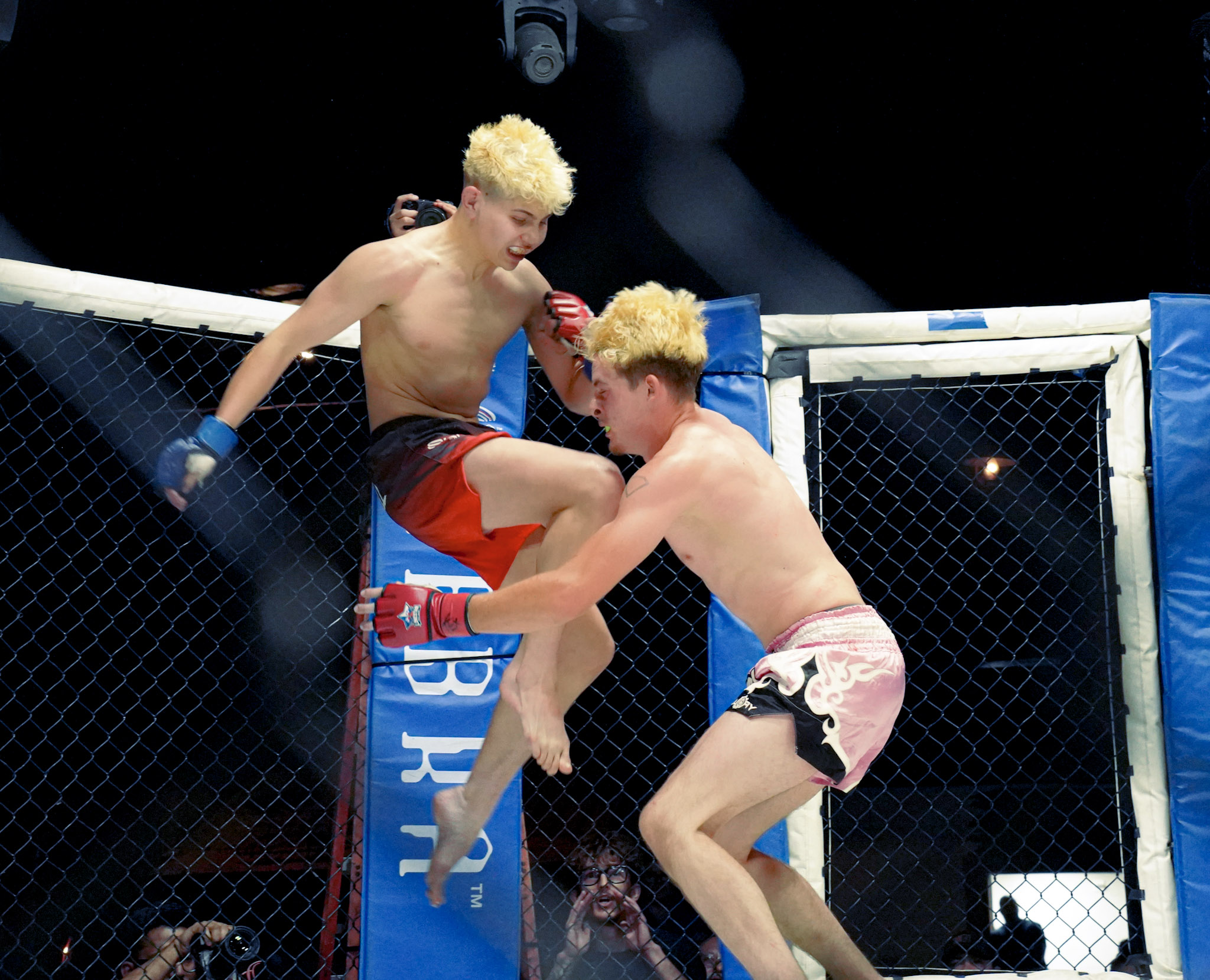 Flying knee MMA action inside the cage